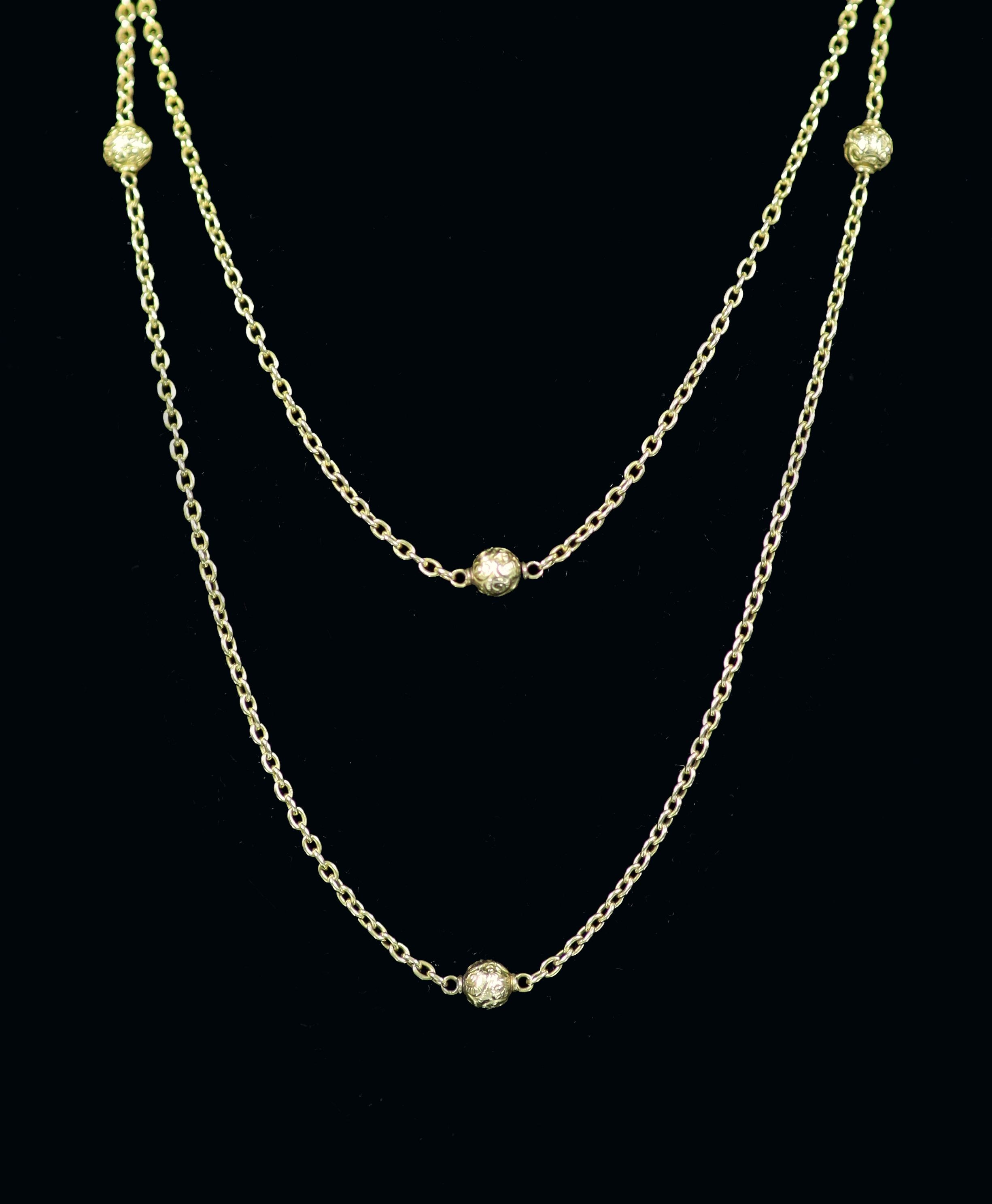 An early 20th century 15ct gold chain link and engraved bead guard chain, 135cm